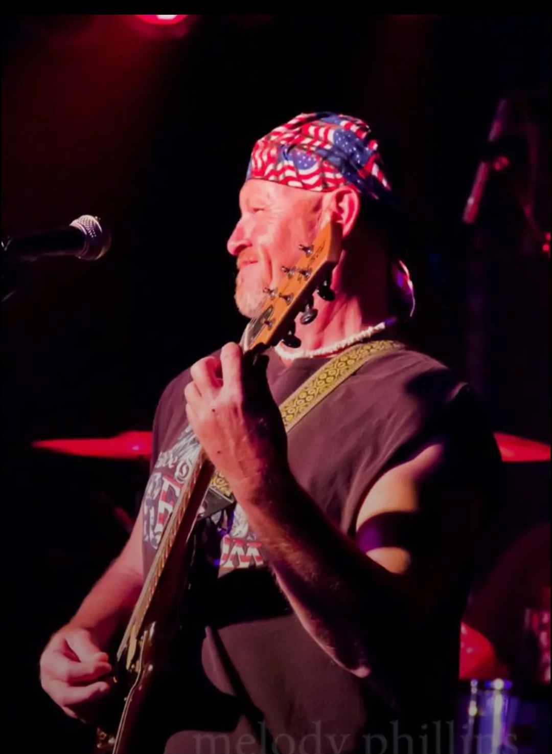 Reuben performing with patriotic bandana and bass guitar