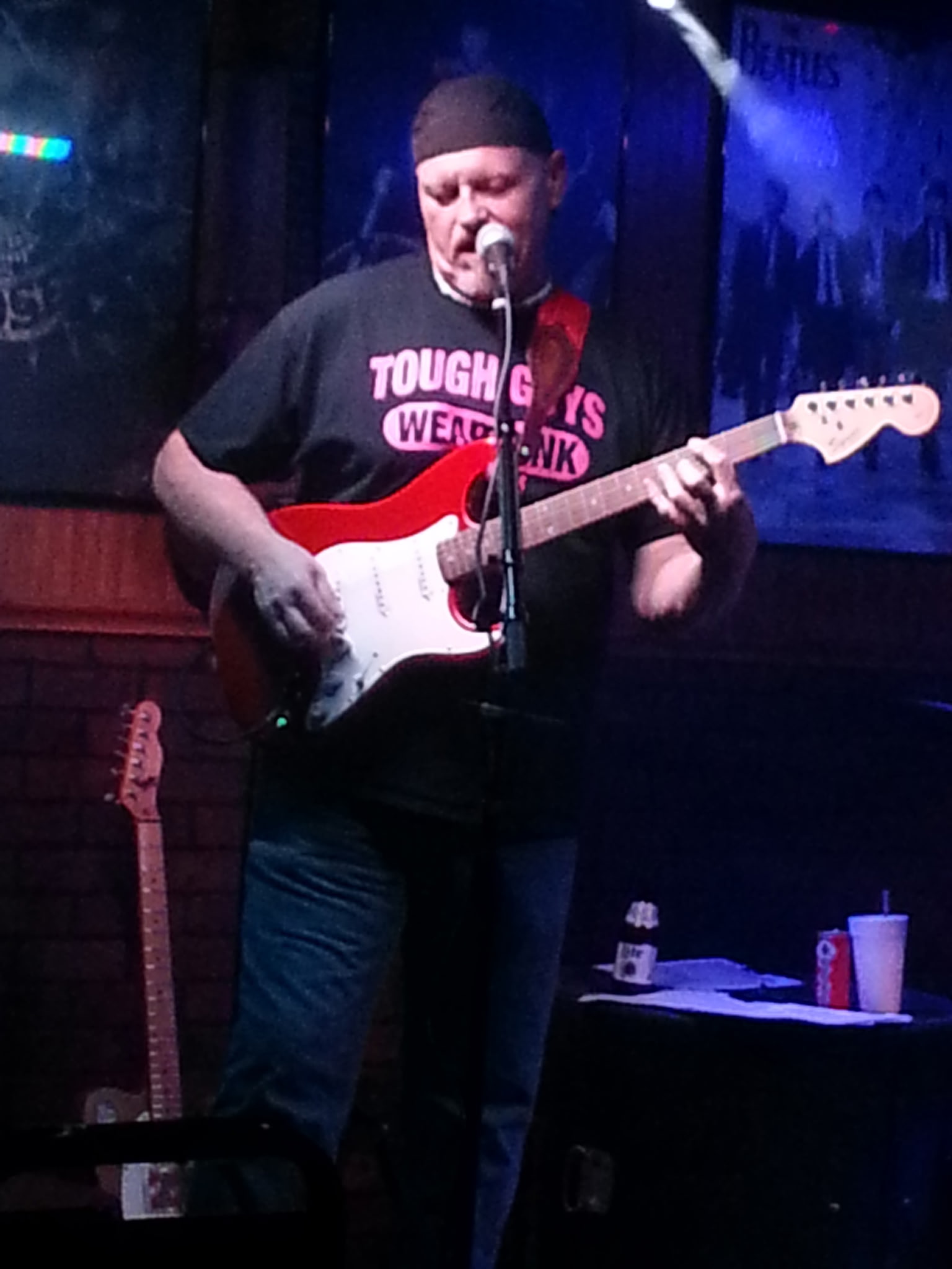 Reuben performing with red Stratocaster guitar